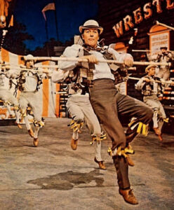 “Dick Van Dyke performing the lively Me Ol’ Bamboo dance number from Chitty Chitty Bang Bang at a village fair.”