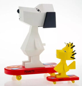 A pair of vibrant, limited-edition skateboard decks featuring abstract reimaginings of Snoopy and Woodstock by artist Nina Chanel Abney. The artworks blend bold primary colors, geometric patterns, and fragmented compositions, juxtaposing the playful innocence of Peanuts characters with contemporary visual chaos. Snoopy is depicted with exaggerated angular features and distorted proportions, while Woodstock appears as a series of overlapping shapes and vibrant hues. The decks incorporate cryptic symbols, text fragments, and layered textures, bridging fine art with skate culture and challenging traditional notions of artistic representation.