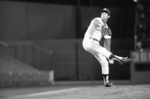 Tommy John pitching on the mound during his MLB career, showcasing the resilience that defined his path to greatness