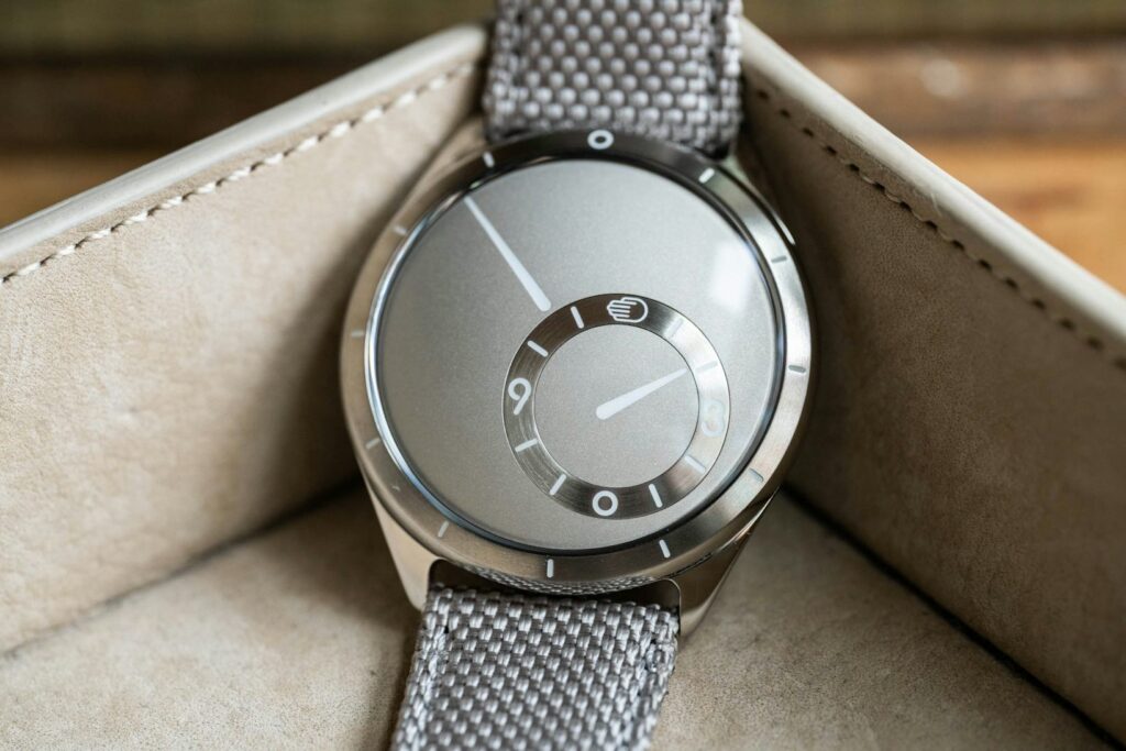Ressence Type 9 compact luxury watch with a sleek titanium case, rotating discs, and minimalist design on a leather strap