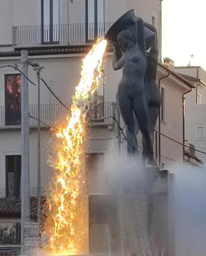 Fontana Luminosa in L’Aquila, Italy, showcasing its glowing lava illusion as sunlight reflects off cascading water streams