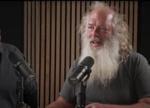 Rick Rubin hosting Tetragrammaton, seated in a serene studio, engaging in a deep conversation with a guest