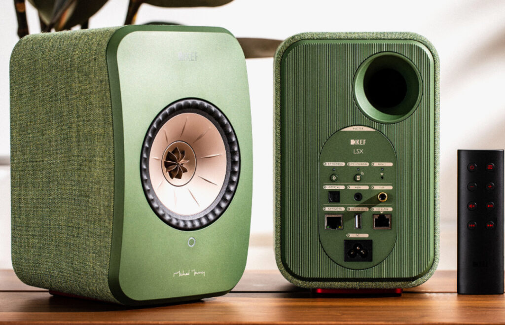 A sleek pair of wireless hi-fi speakers positioned on a modern wooden shelf, showcasing minimalist design and premium build quality