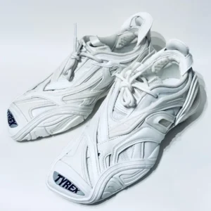 A pair of Balenciaga Tyrex Low White trainers, showcasing white leather, mesh, and unique lacing, evoking style and sophistication