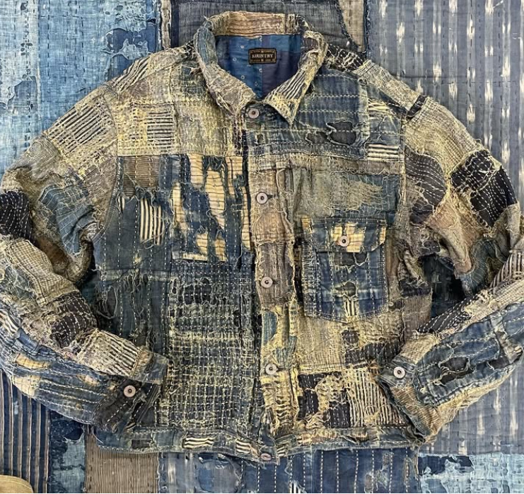 KAPITAL denim jacket with traditional Japanese boro patchwork, indigo dye, and hand-stitched detailing, symbolizing artisanal heritage