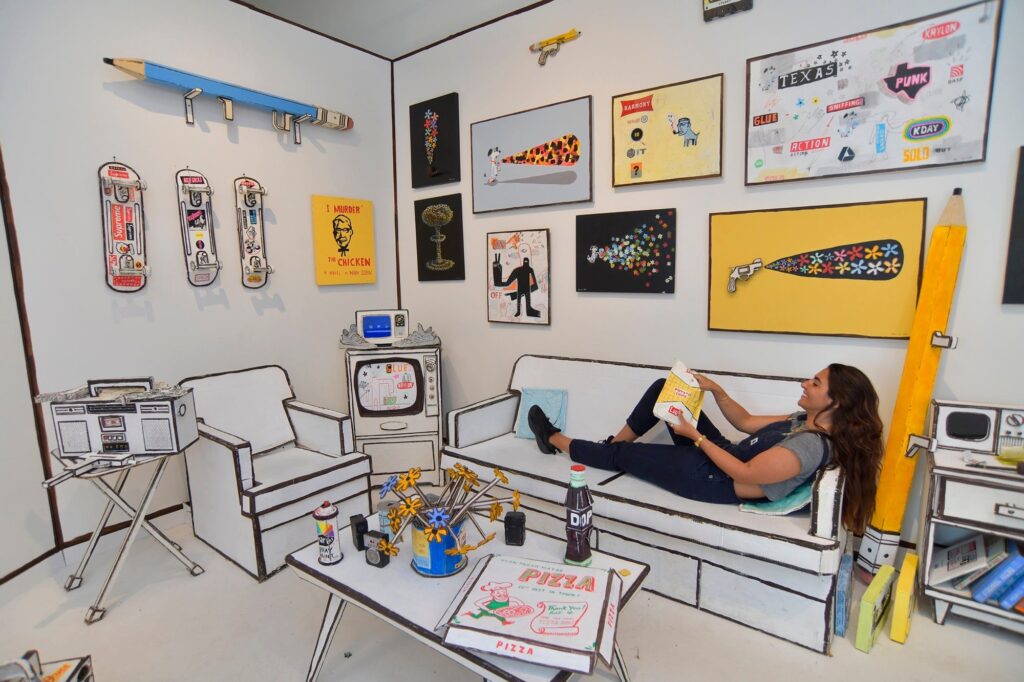 Cardboard sculptures by Bill Barminski on display at the Beyond the Streets 2019 urban art exhibit, showcasing consumer critique