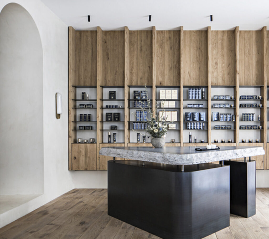 A serene interior of EviDenS de Beauté La Maison in Paris, showcasing minimalist design, luxury skincare products, and calming ambiance