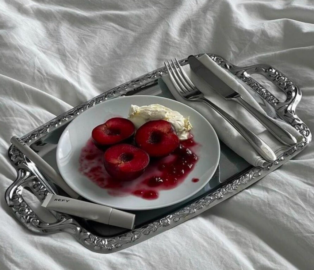 Beauty product displayed on a vintage silver platter with reflective surfaces, adding elegance and depth to the composition