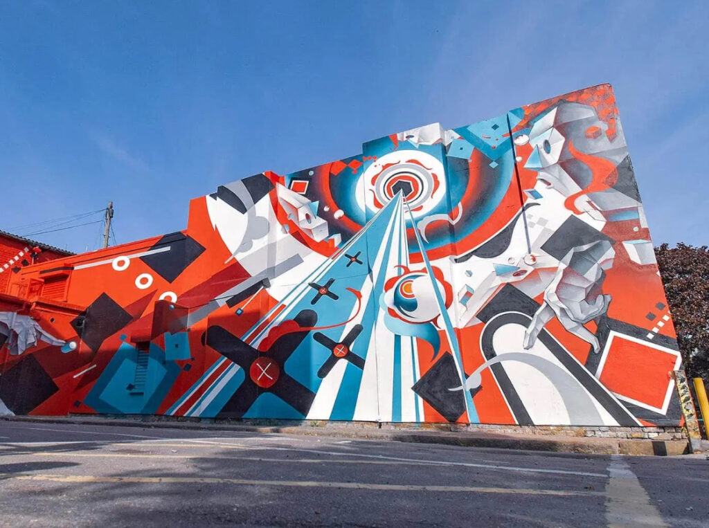 A vibrant mural at Copeland Park by Japanese artists Suiko, Imaone, and Fate, featuring geometric and futuristic styles
