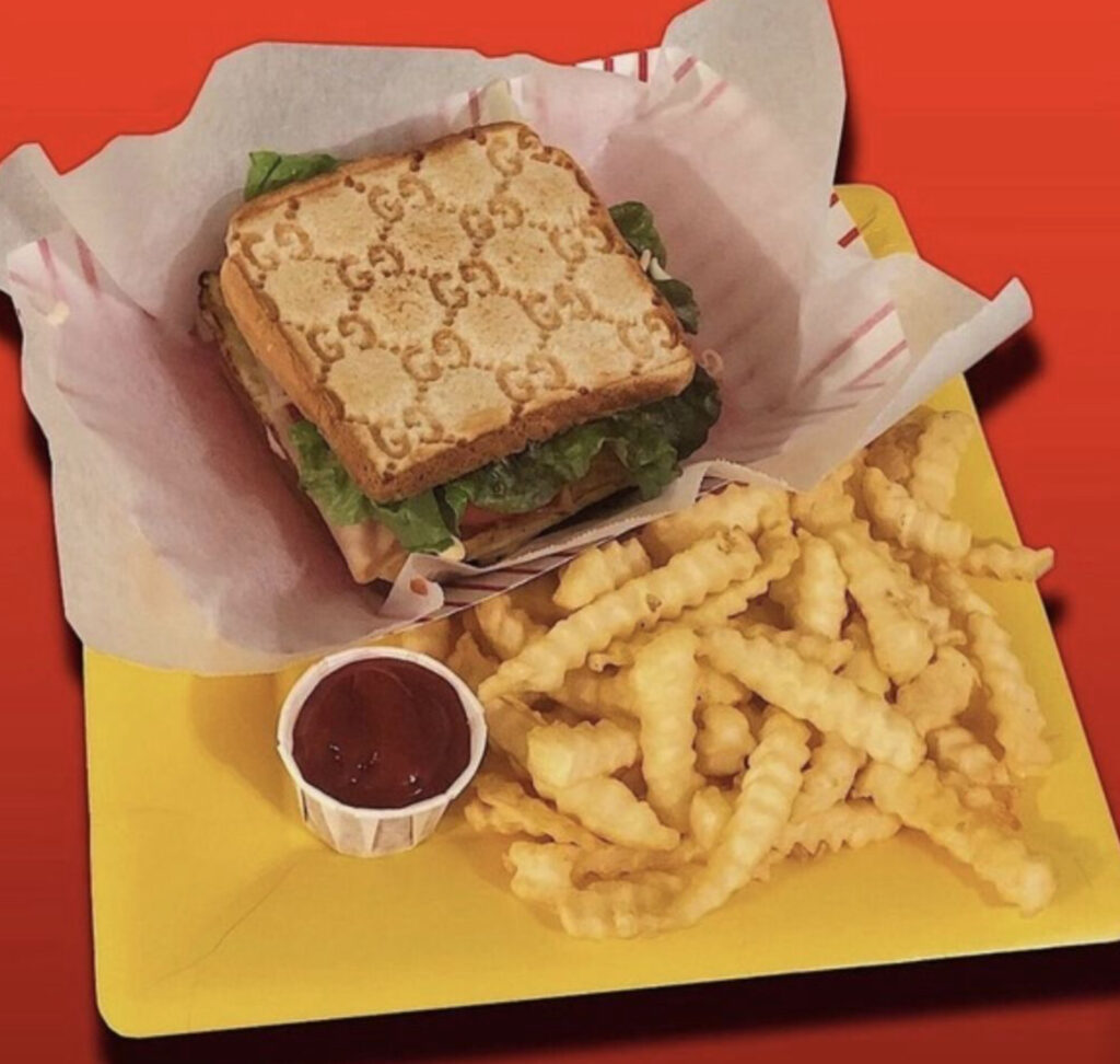 A luxury fashion campaign featuring a designer handbag alongside a decadent plate of pastries, blending food and style