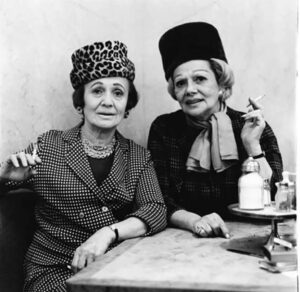 Black-and-white photo by Diane Arbus of two women seated at a table in an NYC automat, showcasing complex emotions and intimacy