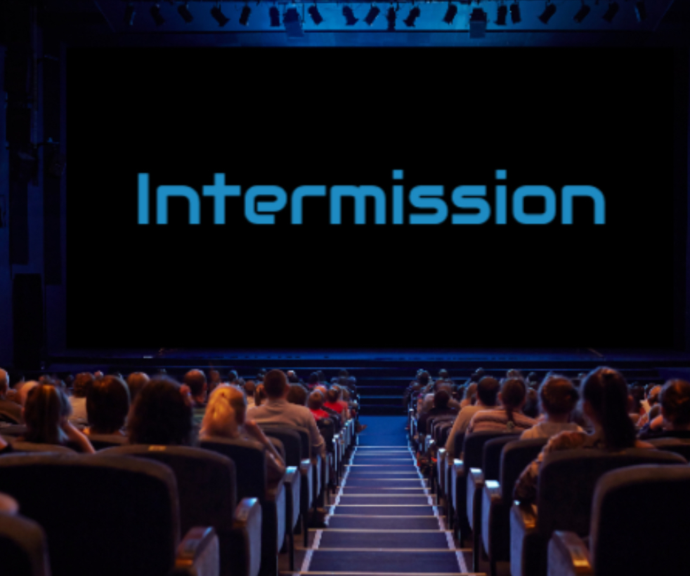 Vintage movie theater with a large “Intermission” sign on screen, people walking around, buying snacks, and chatting