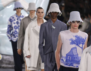 Kim Jones receiving the Légion d’Honneur in Paris, wearing a tailored suit, standing alongside fashion industry leaders