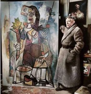 Pablo Picasso working in his Paris studio in 1944, surrounded by paintings and sculptures reflecting wartime themes
