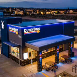 Dutch Bros Coffee drive-thru kiosk with customers ordering beverages, featuring vibrant branding and friendly staff