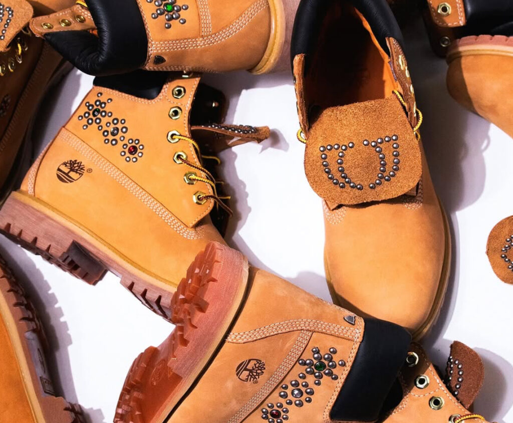 A close-up of the One Block Down x HTC Timberland boot, featuring studded details, Italian flag accents, and premium leather