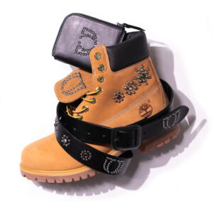 A close-up of the One Block Down x HTC Timberland boot, featuring studded details, Italian flag accents, and premium leather