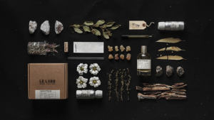A minimalist Le Labo EUCALYPTUS 20 bottle, hand-labeled, placed against a backdrop of eucalyptus leaves and desert sands