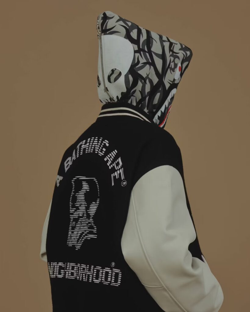 A BAPE x NEIGHBORHOOD varsity jacket featuring co-branded embroidery, camo accents, and military-inspired details