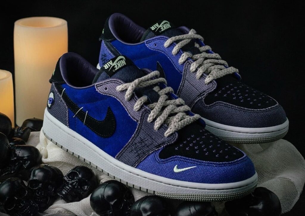 A detailed close-up of the Air Jordan 1 Low OG “Voodoo Alternate,” showcasing blue suede, burlap textures, and voodoo-inspired embroidery