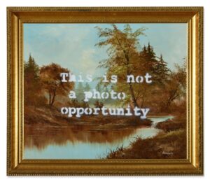 Banksy’s This Is Not a Photo Opportunity stencil graffiti, featuring a hooded figure and bold social commentary text