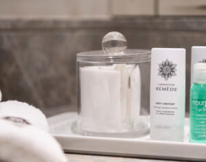 A collection of luxury hotel toiletries, including high-end skincare and fragrance products, elegantly arranged in a hotel bathroom