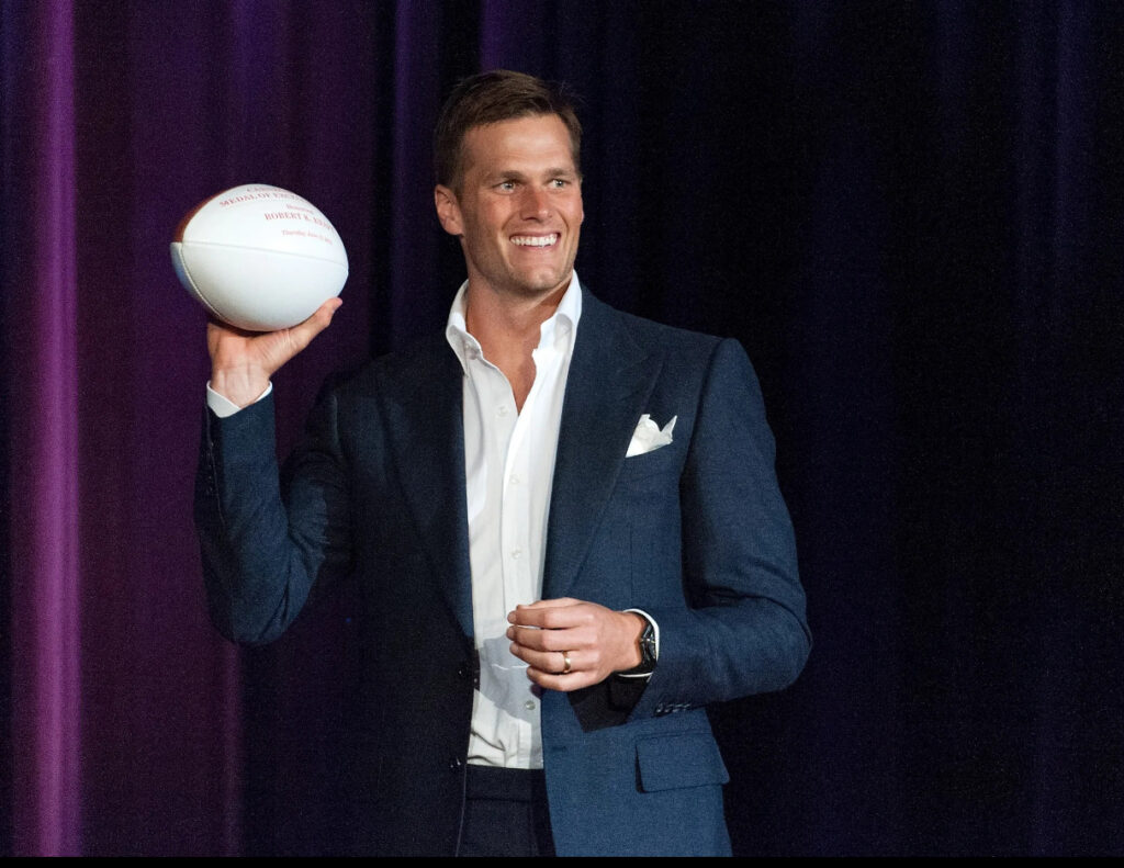 Tom Brady in the Fox Sports broadcast booth, analyzing an NFL game with Kevin Burkhardt, bringing expert insights to fans