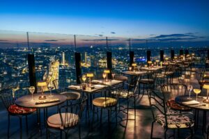 A luxurious room at TOO Hotel Paris, showcasing floor-to-ceiling windows with breathtaking Eiffel Tower and city skyline views