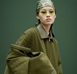 A model wearing a Gucci Pre-Fall 2025 coat with the reimagined Flora motif, showcasing elegant textures and vibrant colors