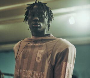 A model from Han Kjøbenhavn’s F/W25 collection wearing urban-inspired fashion with bold, structured silhouettes on the runway