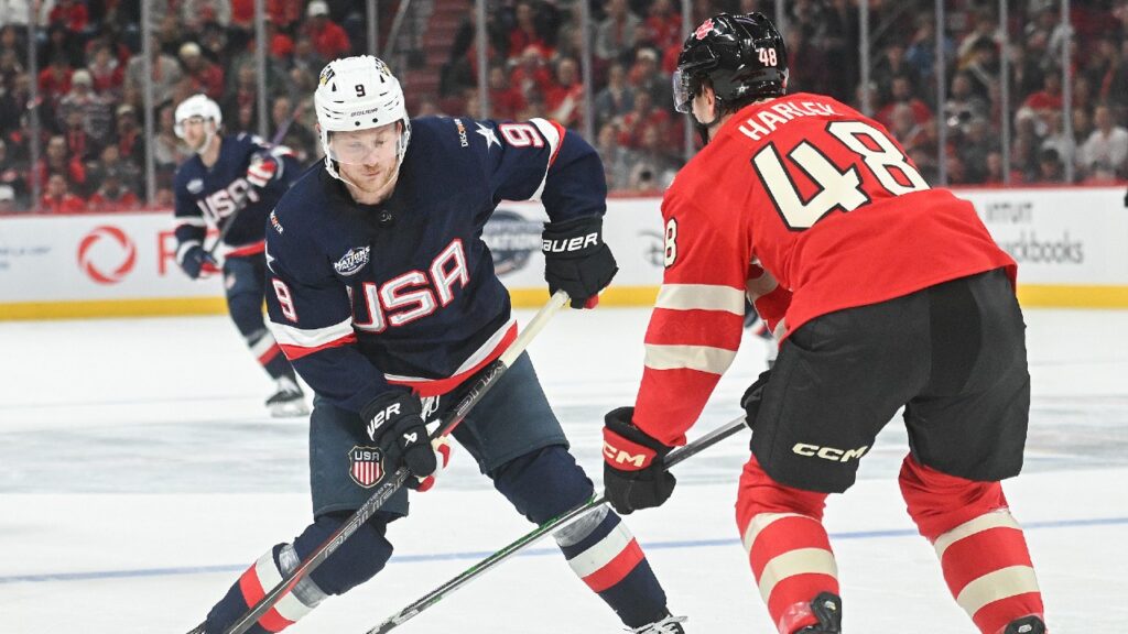 USA and Canada hockey players battling on the ice during the 4 Nations Face-Off championship game, as fans eagerly watch the intense rivalry unfold