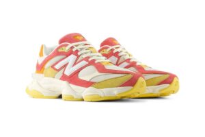 A close-up of the New Balance 9060 "Fluorescent" sneaker, showcasing its fiery red, yellow, and orange color combination