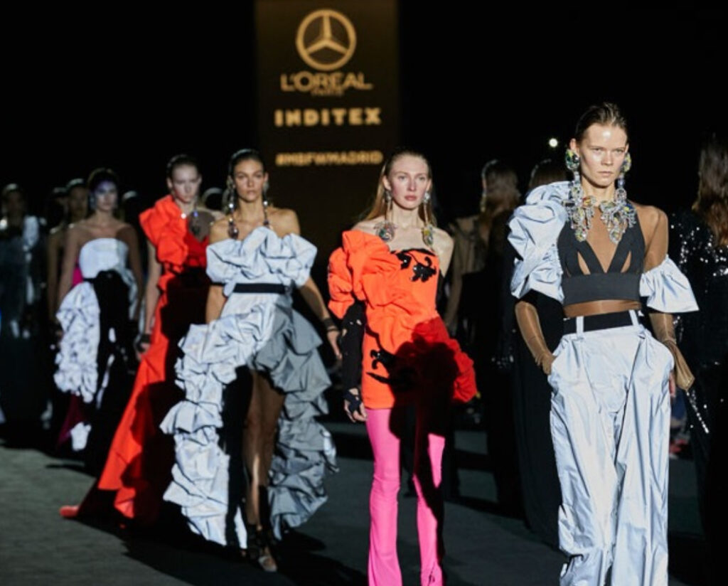 Backstage at Mercedes-Benz Fashion Week Madrid FW25, featuring designers, models, makeup artists, and final runway preparations