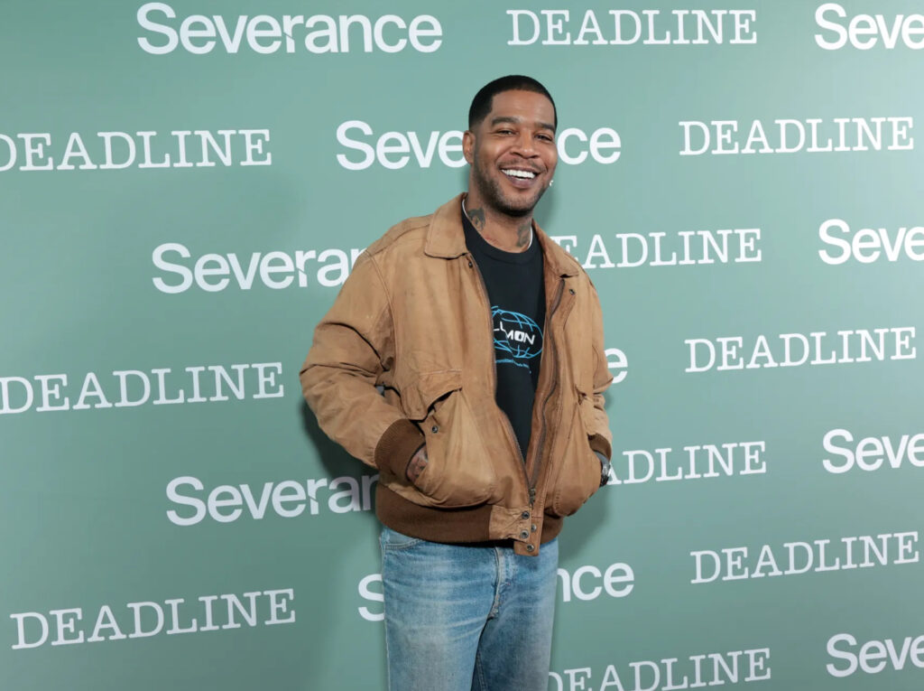 “Kid Cudi’s auctioned items on display, including gold chains, designer sneakers, and vintage music T-shirts.”
