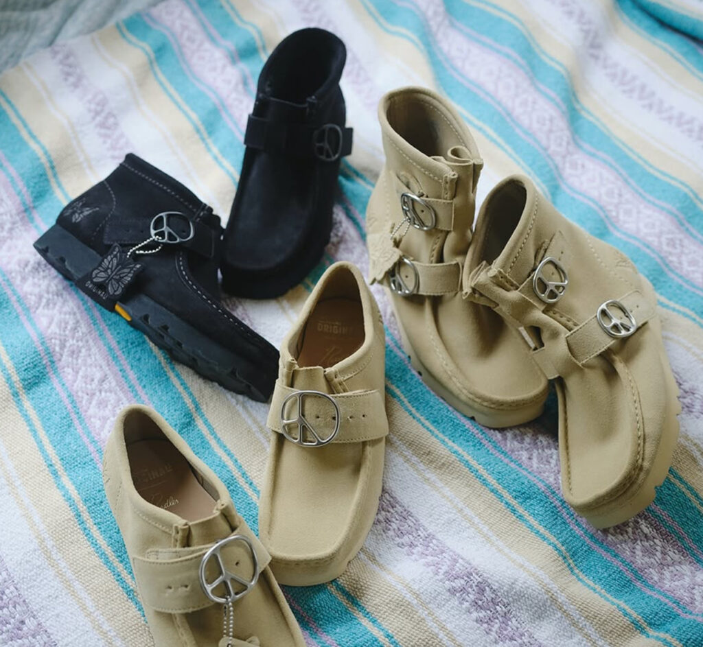NEEDLES and Clarks Wallabee Monk shoe in black suede with metallic monk strap buckle and Vibram sole on display