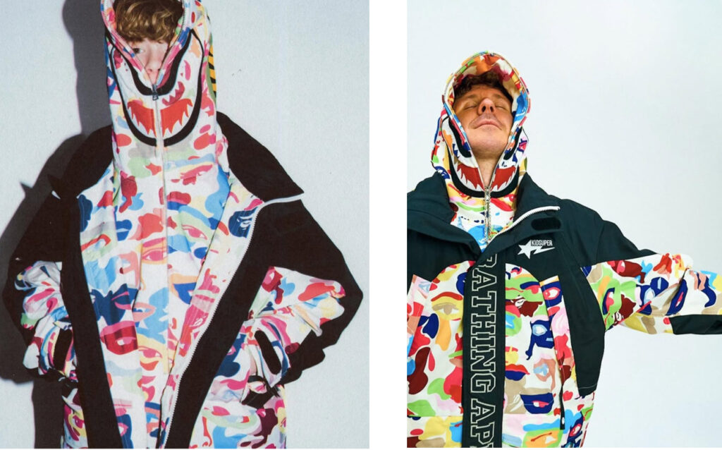 Model wearing BAPE by KidSuper hoodie with graphic camo, standing in a colorful, surreal art-inspired set