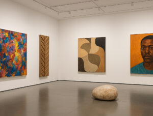 Interior view of an art gallery exhibiting contemporary artworks, illustrating diverse valuation factors