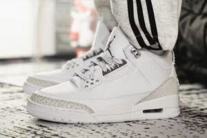 On-foot look at the Air Jordan 3 “Pure Money” 2024 featuring white leather, chrome Jumpman heel, and tonal elephant print