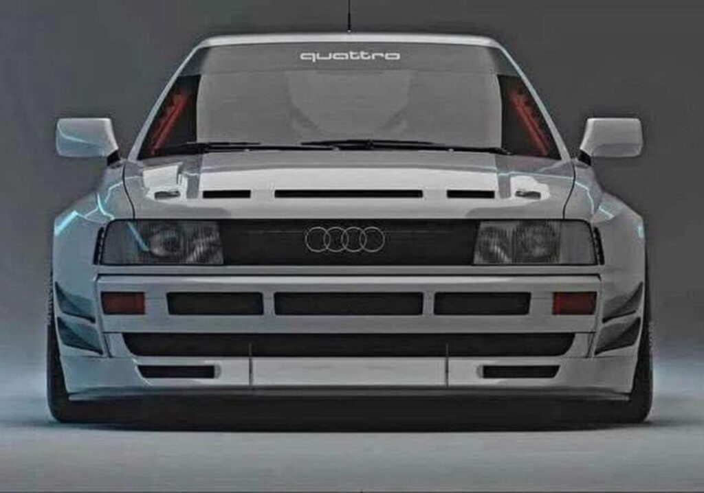 Classic Audi Quattro in white rally trim with flared fenders, parked on gravel with mountains in the background