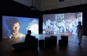 Still from Wang Tuo’s Tungus (2021), featuring a convulsing figure in ritualistic trance, set in a dim, minimal interior