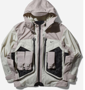 Nike ISPA Butterfly Jacket “Bone” in ripstop nylon with removable sleeves and split-back design, styled against concrete backdrop