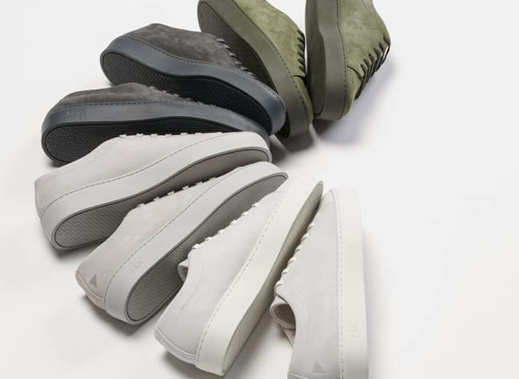 JAK shoes in Bone and Navy on minimalist stone backdrop, showcasing clean lines, European craftsmanship, and neutral tones