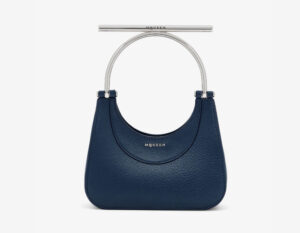 A close-up view of the Alexander McQueen Mini T-Bar Bag in Denim Blue, featuring its structured silhouette and silver T-bar handle