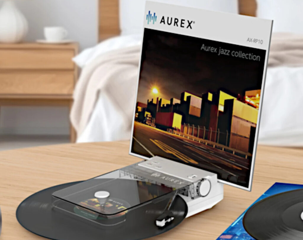 Toshiba Aurex AX-RP10 portable record player with built-in album jacket display, placed on a wood table