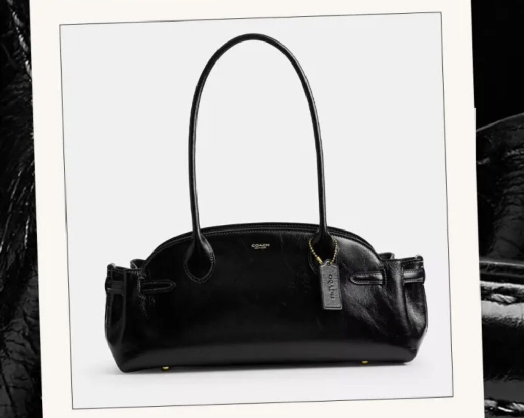 Coach Empire Carryall Bag 34 in glazed leather, photographed against a minimalist background showing structured silhouette and handles