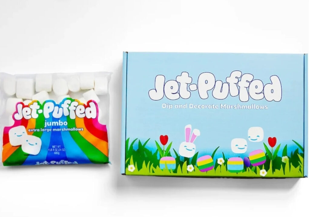 Jet-Puffed DIY Marshmallow Easter Kit with colorful icing, candy decorations, and egg-shaped marshmallows on a spring-themed table