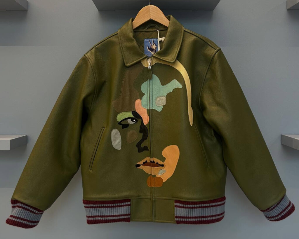 Colorful leather jacket by KidSuper featuring abstract face patchwork design on chest and sleeves