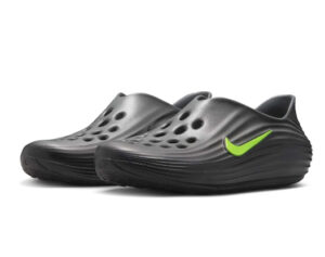 Nike ReactX Rejuven8 shoe in a Black, Cool Grey, and Volt colorway, featuring a breathable mesh upper, Volt green accents, and a sculpted ReactX foam sole designed for recovery and lifestyle wear
