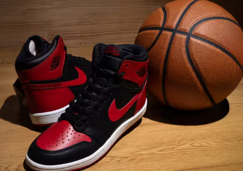 Close-up of the Air Jordan 1 Hi ’85 “Bred” sneaker showing black and red leather upper, white midsole, and classic high-cut profile