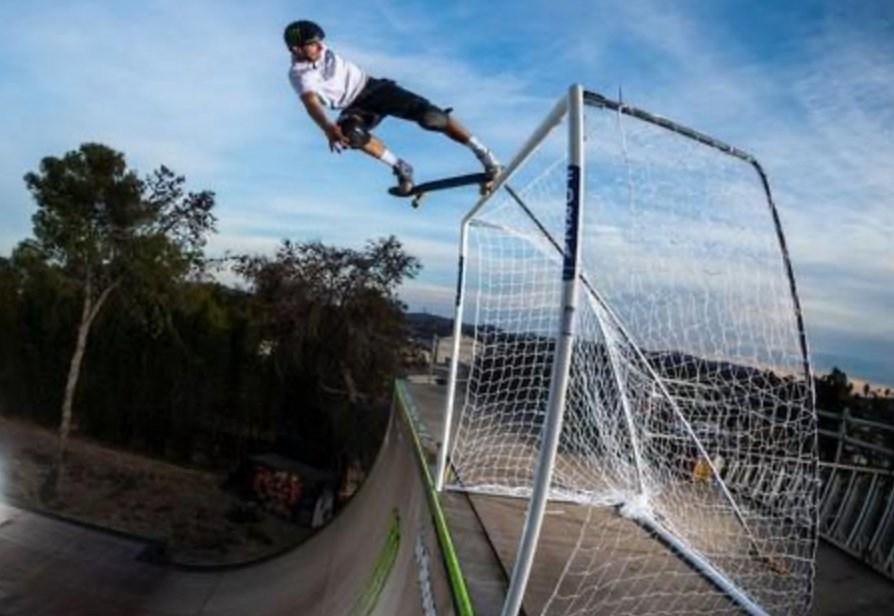 Tom Schaar mid-air during a vert trick, captured against a blue sky, showcasing a high-flying moment from his skate part